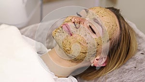 Young woman having face treatment in spa salon