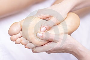 Young woman having feet massage in beauty salon, close up