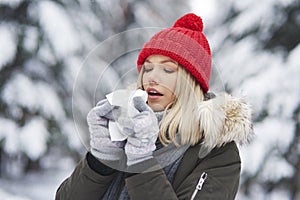 Woman having flu and blowing her nose at handkerchief