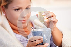 Young woman having flu drinking tea feeling bad
