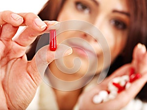 Young woman having flu takes pills.