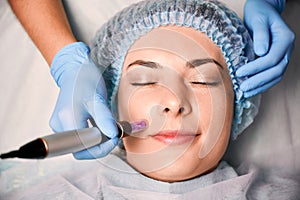 Young woman having fractional mesotherapy at wellness center.