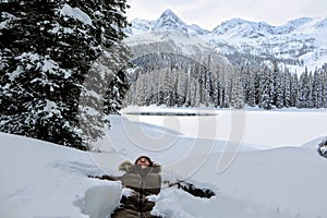 A young woman having fun around Island Lake in Fernie, British Columbia, Canada. The majestic winter background is pretty