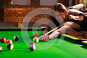 Young woman having fun with billiard.