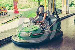 Young woman having fun in electric bumper car