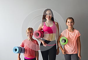 Young woman having fun with kids doing yoga