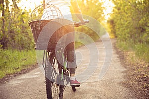 Young woman having fun near countryside park, riding bike, traveling at spring day