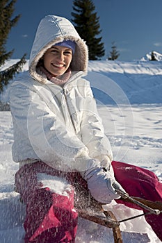 Young woman having fun with sled