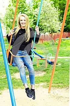 Young woman having fun swinging on a sunny day