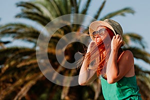 Young woman in the wind by the palm trees