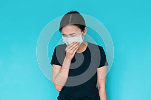 Young woman having headache on blue background.