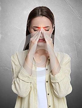 Young woman having headache on light grey background