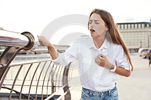Young woman having heart attack on city