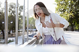 Young woman having heart attack on city street