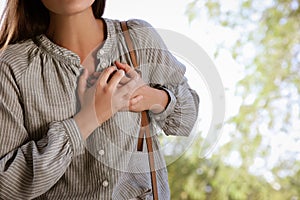 Young woman having heart attack in park, closeup