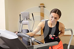 Young woman having heart attack on treadmill