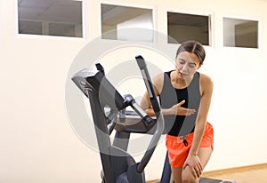 Young woman having heart attack on treadmill