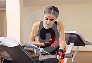 Young woman having heart attack on treadmill