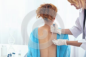 Young woman having her skin examined by a doctor