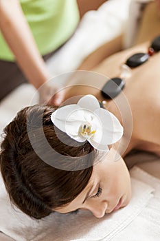 Young woman having a hot stone massage therapy