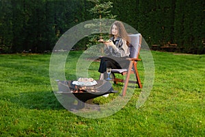 Young woman having late barbecue picnic