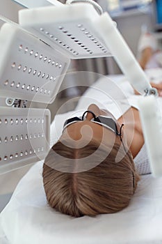 Young woman having LED light facial treatment