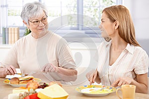 Young woman having lunch with mother smiling