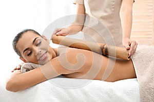 Young woman having massage with bamboo stick