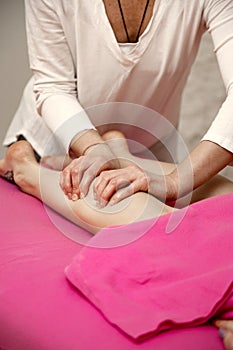 Young woman having massage in spa salon studio.