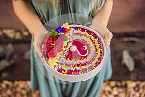 Young woman having a mediterranean breakfast, eats Healthy tropical breakfast, smoothie bowl with tropical fruits