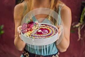 Young woman having a mediterranean breakfast, eats Healthy tropical breakfast, smoothie bowl with tropical fruits