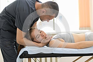 Young woman having osteopathy treatment in the medical cabinet