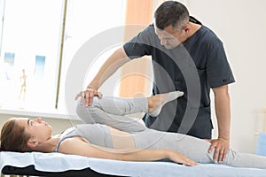 Young woman having osteopathy treatment - pushing on the leg