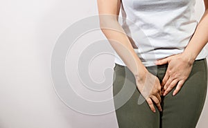 Young woman having painful stomachache with hands holding pressing her crotch lower abdomen