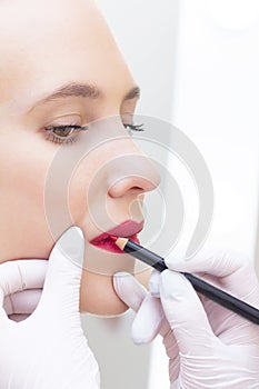 Young woman having permanent makeup on her lip