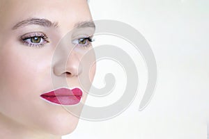 Young woman having permanent makeup on her lips at the beauticians salon