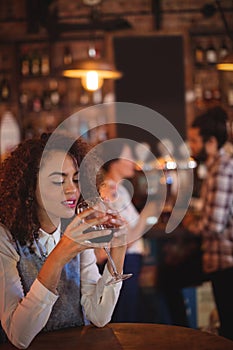 Young woman having red wine in pub