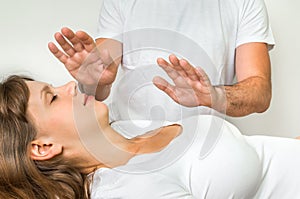 Young woman having reiki healing treatment