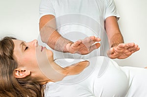 Young woman having reiki healing treatment