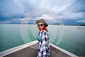 Young woman having a rest at the seacoast. Black Sea landscape. Front view. Travel and vacation. sunglasses and small bag. Batumi