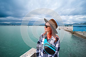 Young woman having a rest at the seacoast. Black Sea landscape. Front view. Travel and vacation. sunglasses and small bag. Batumi
