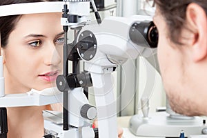 Young woman having an slit-lamp eye test in ophthalmology clinic photo