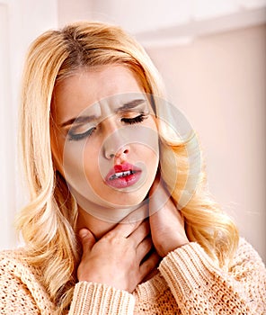 Young woman having sore throat.