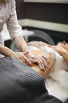 Young woman having stomach massage photo