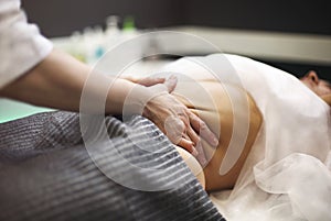 Young woman having stomach massage photo