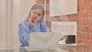 Young Woman having Toothache while Working on Laptop