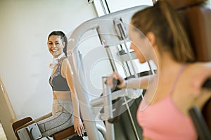 Young woman having a training at abductor machine in the gym