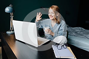 Young woman having video call on her computer at the hottel room.