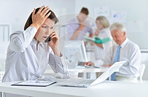 Young woman with headache working in the office