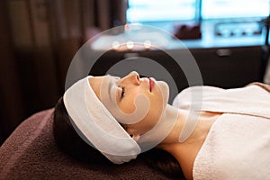 Young woman with headband lying in spa parlor